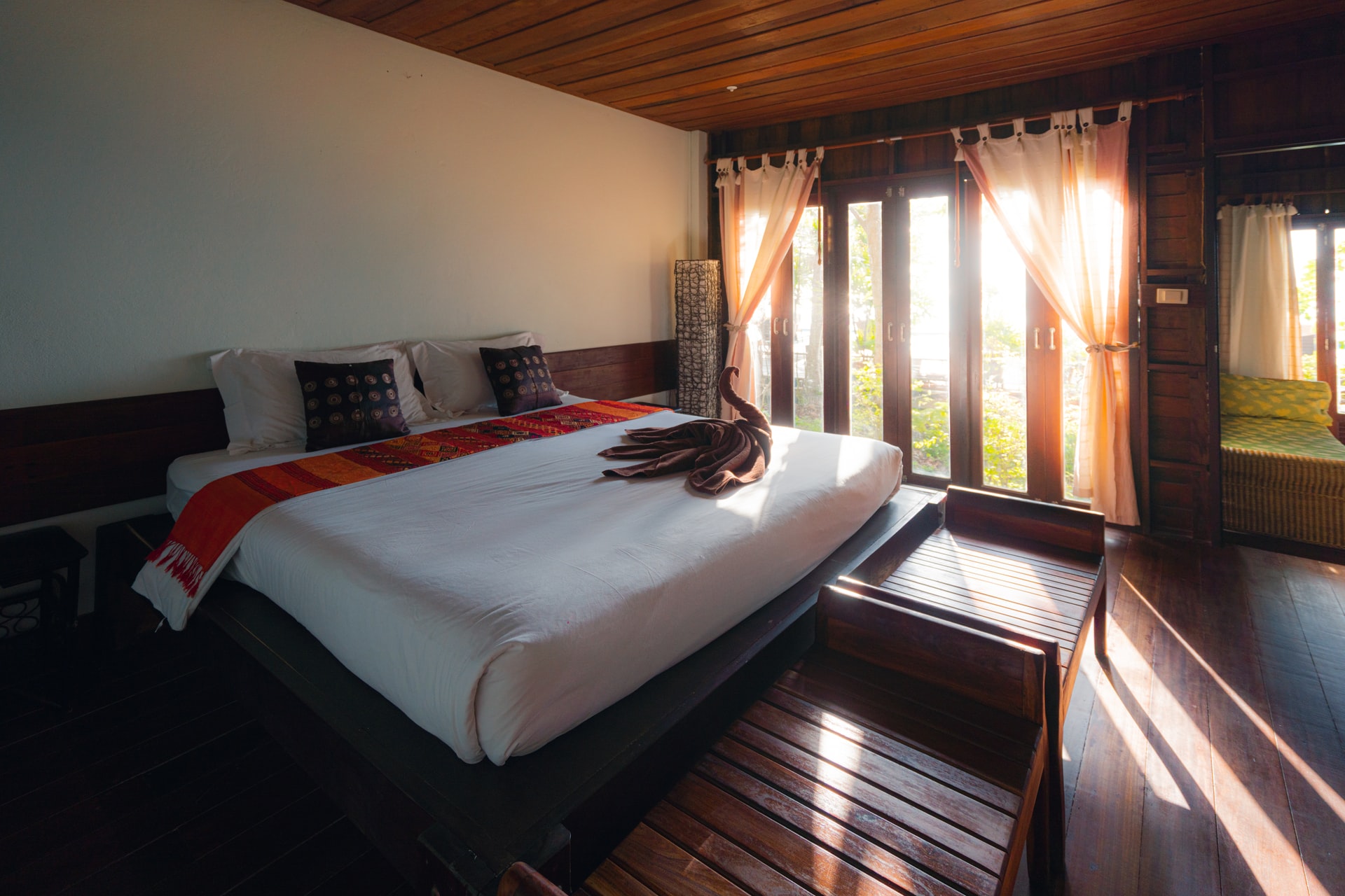 white bed linen near brown window curtain